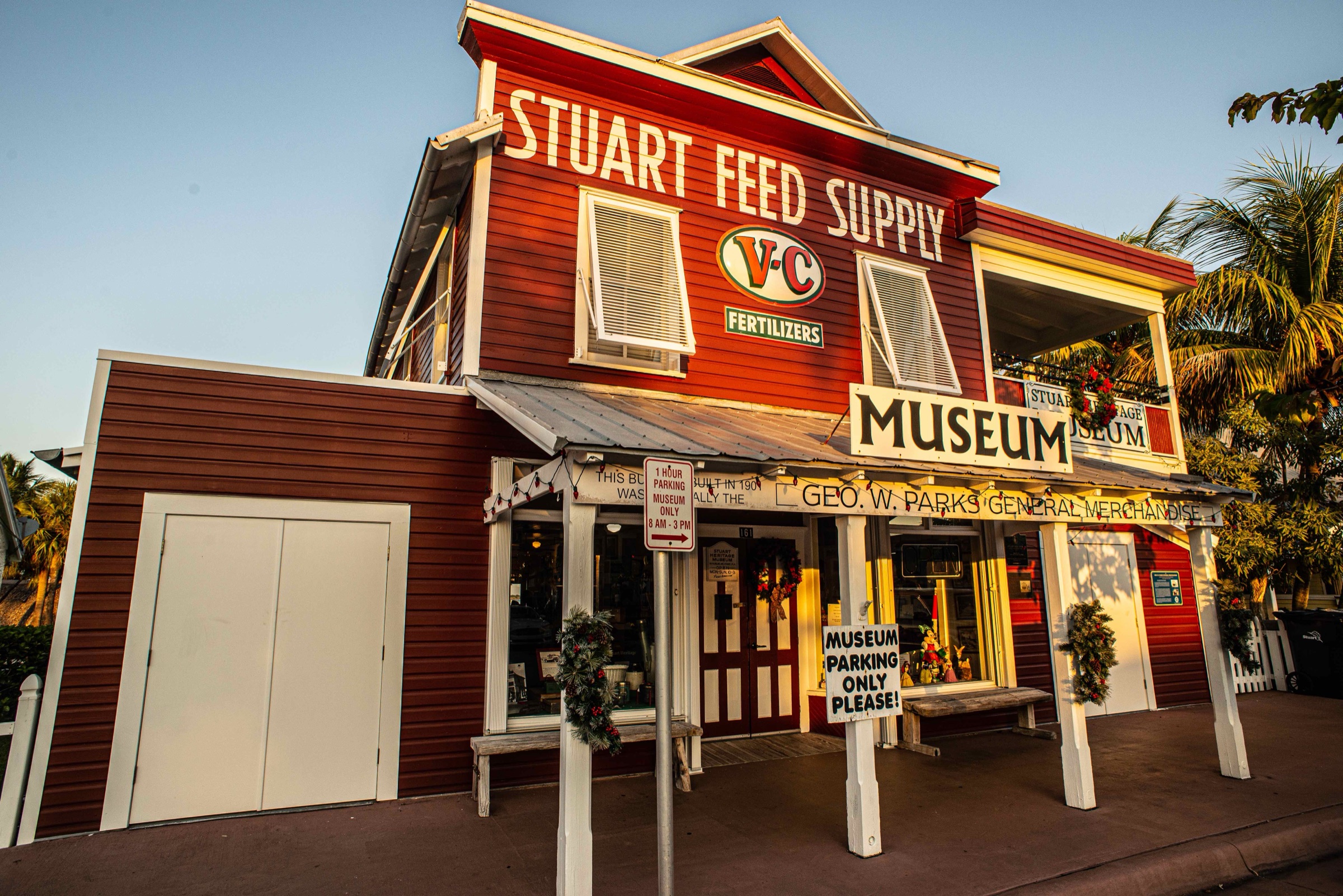 The historic red Stuart Feed Supply building, now the Stuart Heritage Museum in the Geo. W. Parks General Merchandise store, at golden hour in downtown Stuart, Florida.